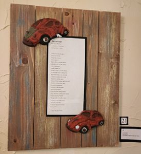 Cockroach poem and ceramic Volkswagen on wood panel 